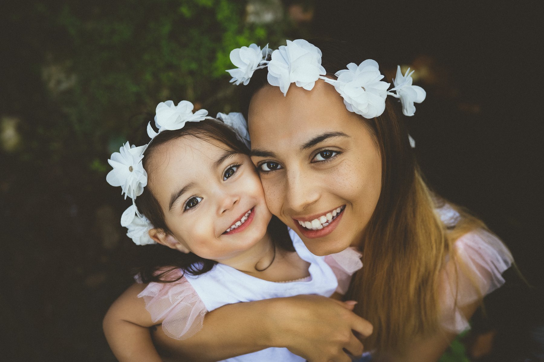 Mãe e filha com coroas de flores, face com face